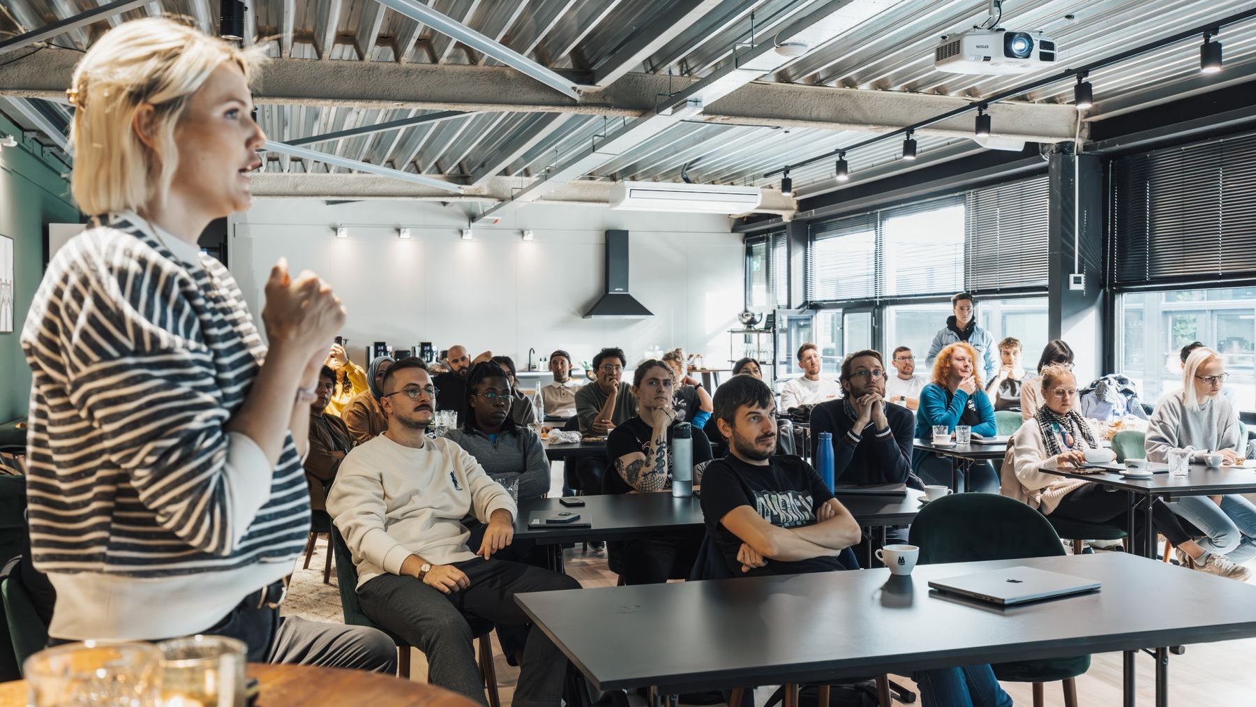 Formatrice animant une session de formation professionnelle devant un groupe de participants